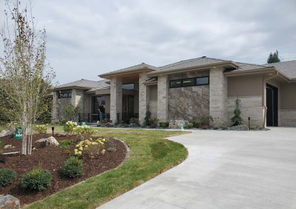 image of a beautiful home with a landscaped yard and curved driveway to highlight the street of dreams