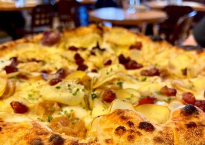 Closer view of the Dolomiti Pizzeria and Enoteca Patata pizza topped with shaved potato and pancetta