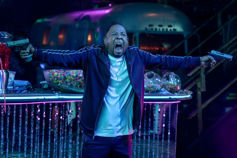 Martin Lawrence as Bad By Marcus Burnett both guns outstretched in a night club
