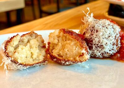 an arancini ball cut in half to show the moist, tender center