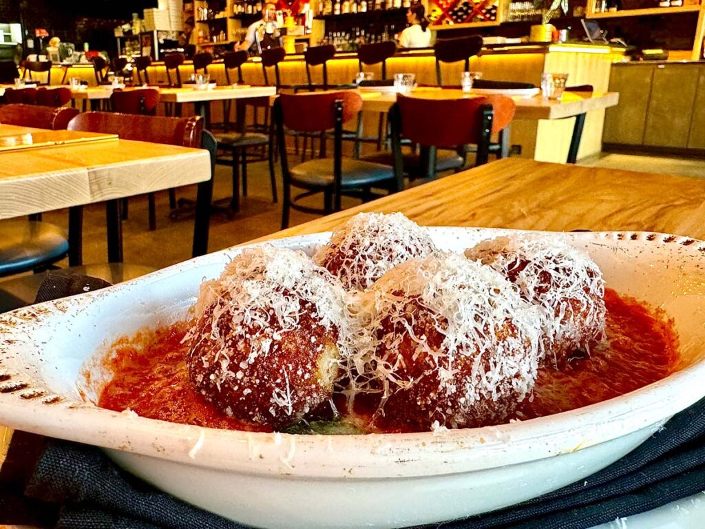 Four arancini balls atop pomodoro sauce