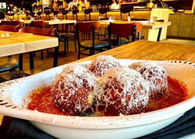 Four arancini balls atop pomodoro sauce