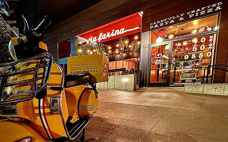 exterior shot of via farina with a yellow delivery scooter in front of the building