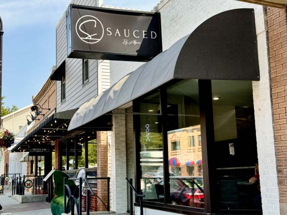 the outside of sauced by alfaro with the sign and front entry way in view