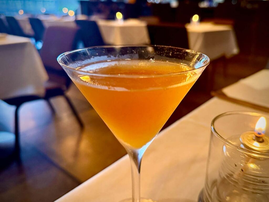 A peach cocktail in a martini glass, the Jamison and the giant peach