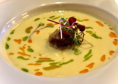 Dolce corn soup with a waygu beef meatball in the center. Microgreens on top