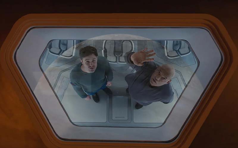 Slingshot film review featured image with Casey Affleck and Laurence Fishburne looking out the window of the spaceship Odyssey