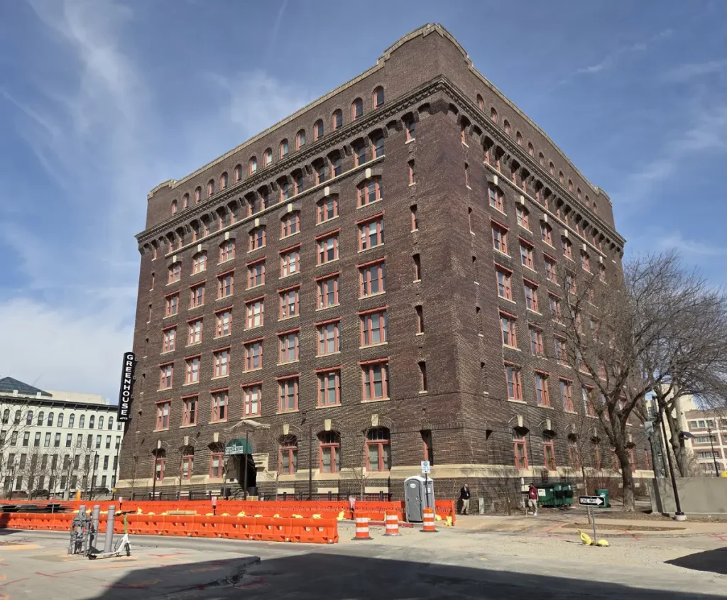 Looking northwest at the entrance of the Greenhouse apartments (McKesson-Robbins Building) with the streetcar construction in progress along Farnam Street.