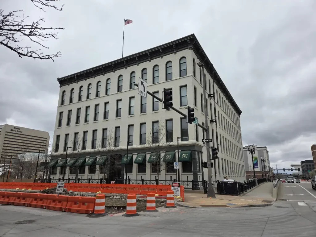2026 photo of the front of Burlington Place from 10th and Farnam. The barricades in front are for the ongoing streetcar construction.