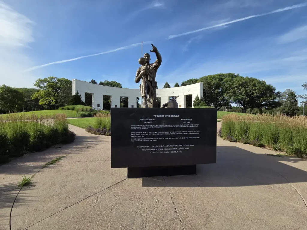 2026 photo of Memorial Park of a monument dedicated to those who served in the Korean Conflict and Vietnam War. The colonnade sits behind it.