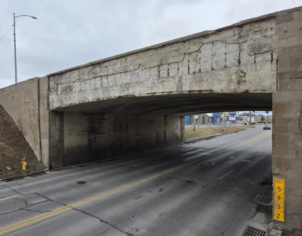 2026 photo of the Saddle Creek Underpass where the decorative stone was removed. Beneath it to the right is the measuring stick that shows how deep the water is when it floods.