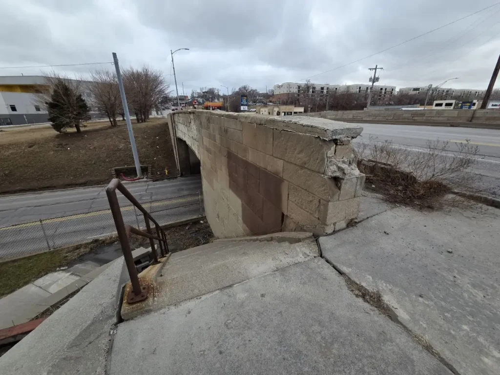 2026 photo of the historic Sutter's Mill sitting at the eastern end of the Saddle Creek Underpass. The red, white, and blue Lincoln Highway markers were originally used to guide motorists traveling along the highway.