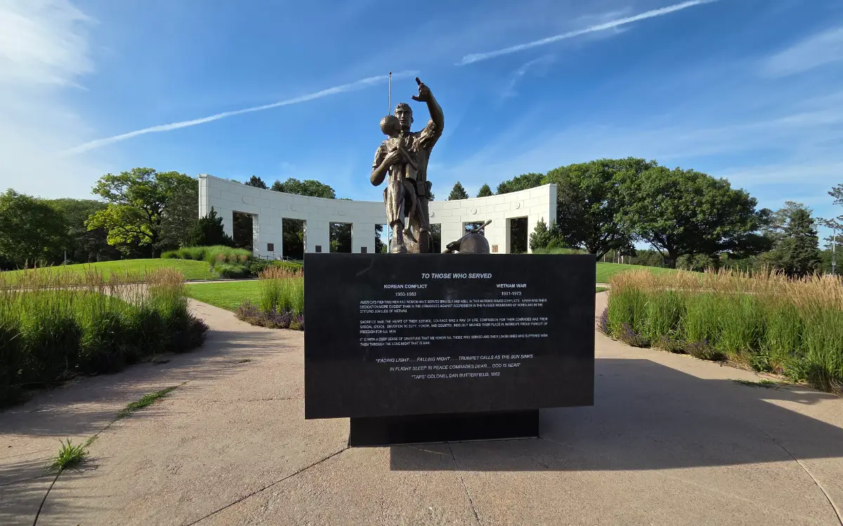 2026 photo of Memorial Park of a monument dedicated to those who served in the Korean Conflict and Vietnam War. The colonnade sits behind it.
